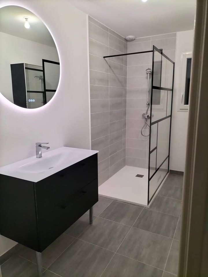 Photo réelle — Salle d’eau : meuble suspendu et douche vitrée à Localisation non précisée