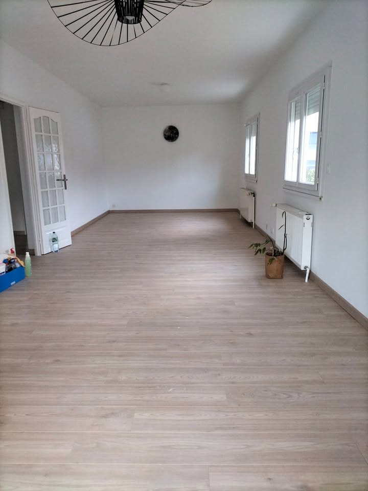 Photo réelle — Pièce de vie : sol d’aspect bois et luminaires à Localisation non précisée